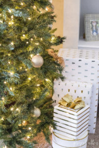Modern glam Christmas tree and Gold and white Christmas gifts with a gold bow.