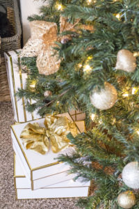 Modern glam Christmas tree and Gold and white Christmas gifts with a gold bow.