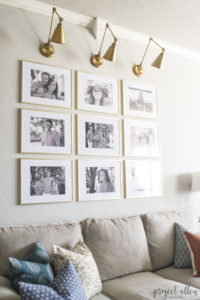Creating a Grid Style Gallery Wall with these easy tips and tricks. Brass matted picture frames, brass swing arm sconces turned into a gallery wall creates the perfect backdrop for our sofa.