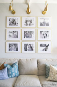 Creating a Grid Style Gallery Wall with these easy tips and tricks. Brass matted picture frames, brass swing arm sconces turned into a gallery wall creates the perfect backdrop for our sofa.