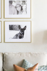 Creating a Grid Style Gallery Wall with these easy tips and tricks. Brass matted picture frames, brass swing arm sconces turned into a gallery wall creates the perfect backdrop for our sofa.