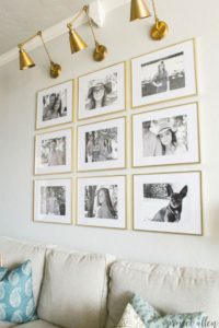 Creating a Grid Style Gallery Wall with these easy tips and tricks. Brass matted picture frames, brass swing arm sconces turned into a gallery wall creates the perfect backdrop for our sofa.