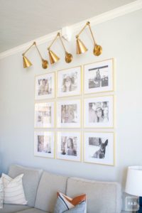 Welcome to our Spring Home Tour: See how we transformed our home with just a few simple changes, a brass frame gallery wall with gold swing arm sconces frame this neutral sofa adorned with mudcloth and leather pillows.