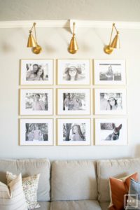 Welcome to our Spring Home Tour: See how we transformed our home with just a few simple changes, a brass frame gallery wall with gold swing arm sconces frame this neutral sofa adorned with mudcloth and leather pillows.