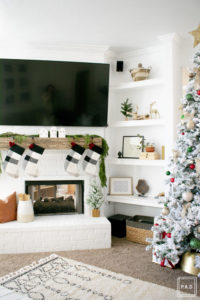 A flocked Christmas tree decorated in red, green and gold gives a big dose of nostalgia to this modern farmhouse living room.