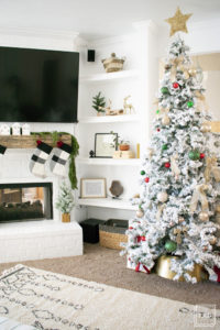A flocked Christmas tree decorated in red, green and gold gives a big dose of nostalgia to this modern farmhouse living room.