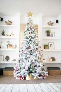 A flocked Christmas tree decorated in red, green and gold gives a big dose of nostalgia to this modern farmhouse living room.