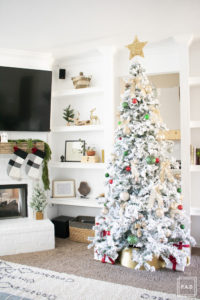 A flocked Christmas tree decorated in red, green and gold gives a big dose of nostalgia to this modern farmhouse living room.