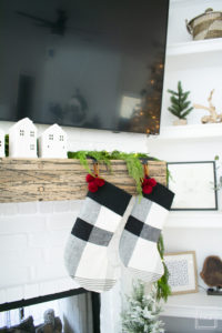 A snowy flocked Christmas tree decorated in red, green and gold gives a big dose of nostalgia to this modern farmhouse living room.