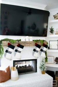 A snowy flocked Christmas tree decorated in red, green and gold gives a big dose of nostalgia to this modern farmhouse living room.
