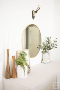breath of fresh air spring home tour: Neutral console table with table skirt styled with modern accents like the amazing mcm candlesticks and rustic antlers.