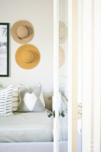 breath of fresh air spring home tour: This office turned guest room is so fun with the framed camel print by Taylor Routt and the fun hats used as wall decor.