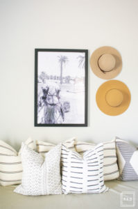 breath of fresh air spring home tour: This office turned guest room is so fun with the framed camel print by Taylor Routt and the fun hats used as wall decor.