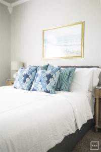 breath of fresh air spring home tour: Modern guest bedroom takes on a more coastal feel with the framed beach print and pops of blue pillows